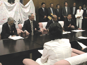 日本共産党がよびかけた条例改正案の今議会での提出・成立を要請する首長ら(奥)。手前は石坂県議団長=22日、長野県議会